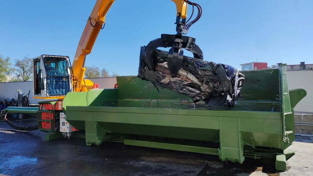 Pressa per autodemolizioni Idromec mentre compatta una carrozzeria auto