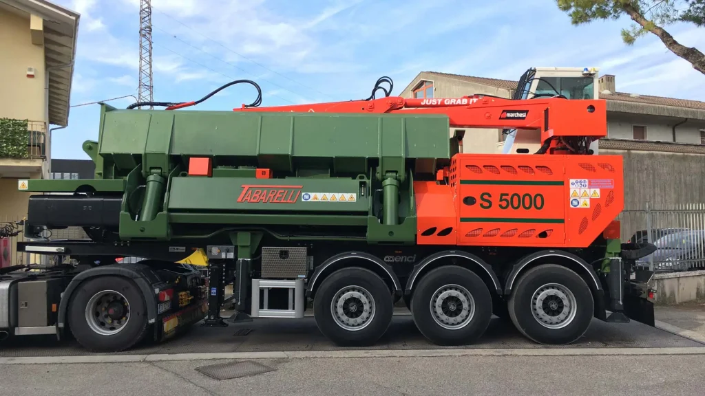 Pressa per autodemolizioni Idromec montata su camion con braccio idraulico in vista laterale durante il trasporto