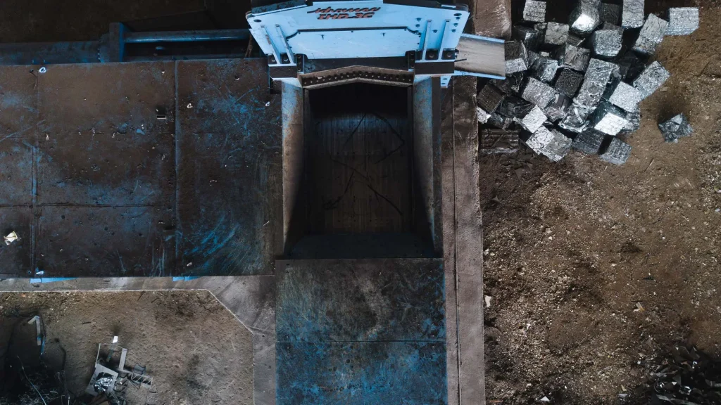 Draufsicht auf die Presskammer der Drei Kompressionspresse IHD-3C Idromec mit verdichteten Metallpaketen